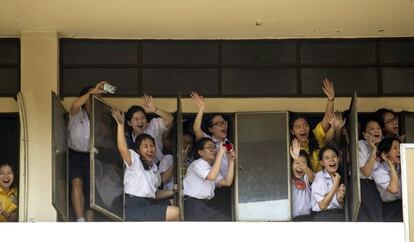 Alumnas de una escuela animan, desde las ventanas de su clase, el convoy de manifestantes que protestan contra el gobierno en Bangkok, Tailandia.