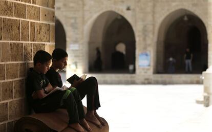 Dos jóvenes palestinos leen unas copias del Corán en una mezquita de Gaza, el primer día del Ramadán.