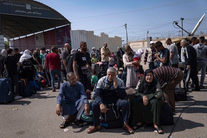 Un grupo de palestinos esperan en el paso fronterizo de Rafah, este lunes. 
