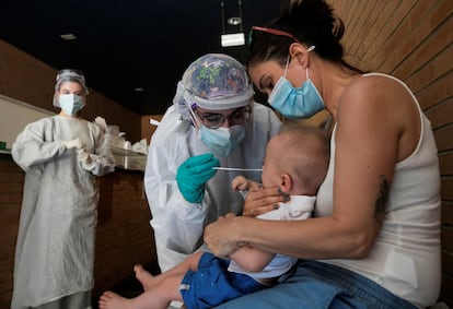 Una sanitaria realiza una PCR a un niño en un espacio habilitado fuera de un centro de salud de Zaragoza, en julio.