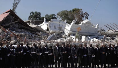 Un grupo de jueces rinde tributo a sus amigos y familiares muertos, durante una ceremonia frente a los restos del que fuera el Palacio de Justicia en Puerto Príncipe