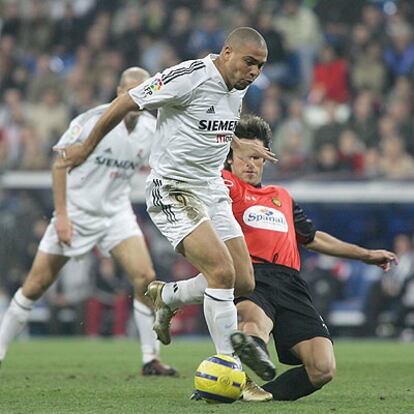 Ronaldo avanza con el balón y un rival lanza el pie en un intento para cortar su trayectoria.