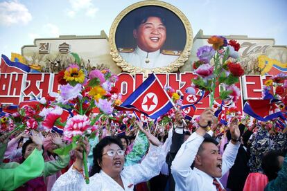 Participantes en el desfile ondean banderines a su paso bajo una imagen de Kim Jong Un.El Ejército Popular norcoreano también mostró al mundo proyectiles de diversos tamaños -entre ellos un gran misil que según expertos podría ser el KN-08 capaz de alcanzar territorio continental de EEUU- así como sus lanzaderas móviles y varios drones, en toda una exhibición de músculo militar.