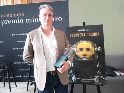 Sabino Cabeza posa con el premio. Detrás, la portada de su novela, 'Frontera oscura'.