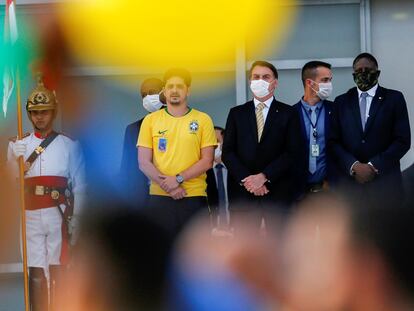 O presidente Jair Bolsonaro observa apoiadores da entrada do Palácio do Planalto, em Brasília, na sexta-feira, 15 de maio.