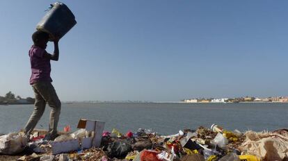 Un niño vuelca un cubo de basura a las orillas del río Senegal, en Saint Louis.