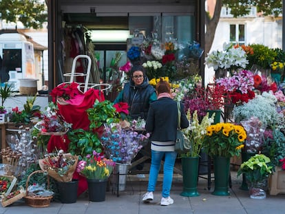 Una joven compra flores en un puesto de flores en la Alameda Principal de Málaga.