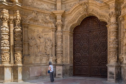 Una mujer contempla el pórtico de la catedral de Santa María, en Astorga.