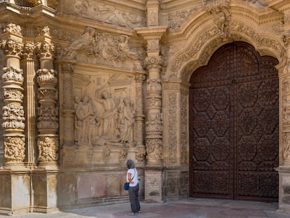 Una mujer contempla el pórtico de la catedral de Santa María, en Astorga.