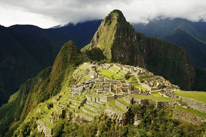 Vistas desde la ladera del cerro Machu Picchu, con el yacimiento arqueológico protegido por el Huayna Picchu (2.720 m) al fondo.
 