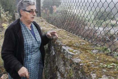 Áurea Bouzón, prima del detenido, muestra, desde la parcela de su casa, hasta donde llegaron las llamas del incendio de Boiro.