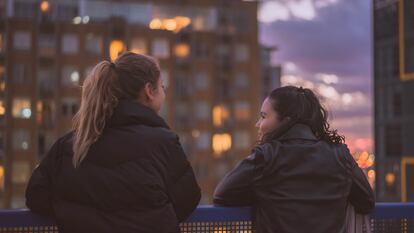 Dos adolescentes charlan en la terraza. A veces, a los padres les cuesta comunicarse con ellos.