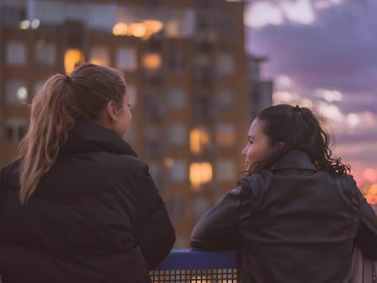 Dos adolescentes charlan en la terraza. A veces, a los padres les cuesta comunicarse con ellos.
