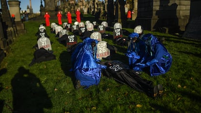 Ativista com máscara de Boris Johnson e cartaz com os dizeres “Onde está o dinheiro para o clima?”, nesta sexta-feira, nas imediações da cúpula de Glasgow.