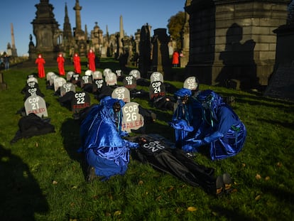 Ativista com máscara de Boris Johnson e cartaz com os dizeres “Onde está o dinheiro para o clima?”, nesta sexta-feira, nas imediações da cúpula de Glasgow.