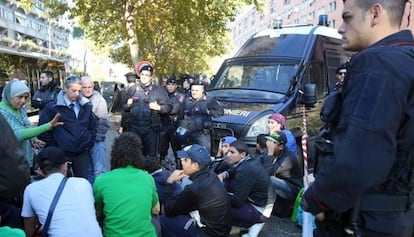 La polic&iacute;a vigila a un grupo de refugiados, este viernes en el barrio de Tor Sapieza, a las afueras de Roma. 