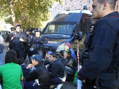 La polic&iacute;a vigila a un grupo de refugiados, este viernes en el barrio de Tor Sapieza, a las afueras de Roma. 