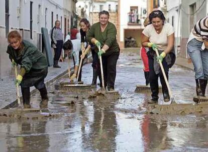 Vecinas de la barriada utrerana Coca de la Piñera limpian el lodo de las calles tras la inundación de la madrugada del miércoles. 
/ garcía cordero
Reyes Álvarez y su marido, Juan Gago, frente a su casa.