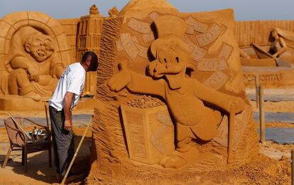 Uno de los artistas del festival trabaja en su escultura del tio Gilito.