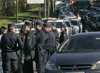 <i>Antidisturbios</i> vigilan la concentración de taxistas en los alrededores de la Plaza de Cibeles a mediodía de ayer.