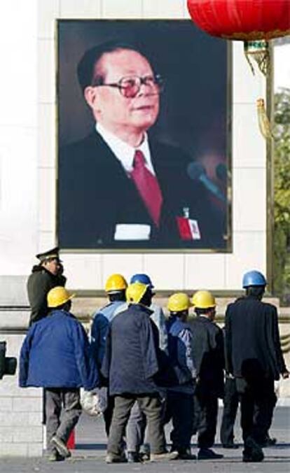 Un grupo de trabajadores ante un retrato de Jiang Zemin, ayer en Pekín.
