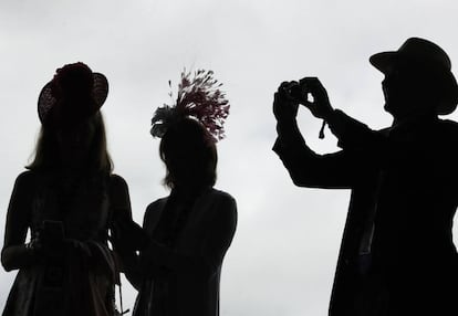 Un hombre toma una foto de dos mujeres, en una carrera de caballos en Kentucky, el pasado 3 de mayo.
