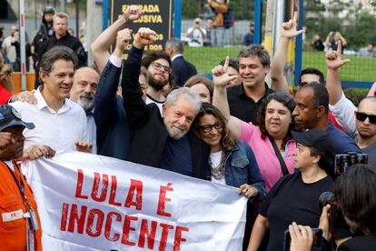 O ex-presidente Lula ao deixar a prisão em Curitiba, abraçado pela namorada e por apoiadores. 
