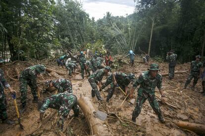 Miembros del ejército buscan supervivientes entre en lodo tras una avalancha en Purworejo, Indonesia.