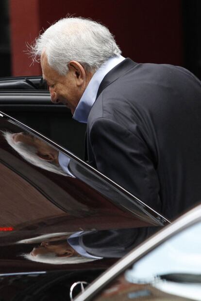 Dominique Strauss-Kahn  entra en un coche para abandonar su apartamento en Nueva York, ayer.