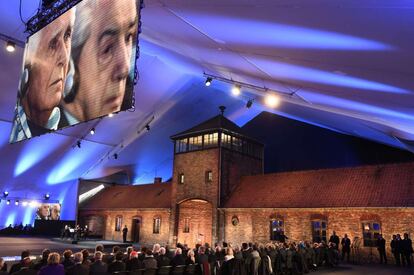 Un pantalla gigante muestra im&aacute;genes de los supervivientes de Auschwitz durante la ceremonia que ha tenido lugar frente a la entrada del campo de concentraci&oacute;n