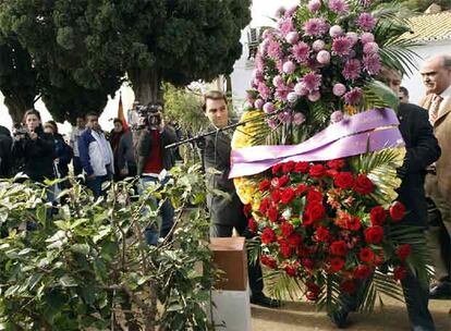 El alcalde de Paterna, Lorenzo Agustí, izquierda, contempla cómo los operarios depositan una corona de flores con los colores de la República.