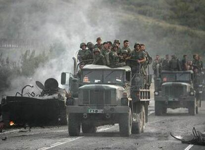 Soldados georgianos pasan junto a los restos de un carro de combate de su Ejército mientras dejan su posición en Gori, a 80 kilómetros de la capital.
