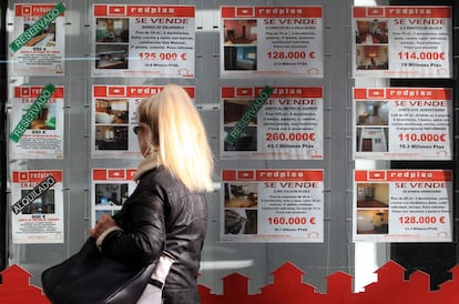 Carteles con pisos en venta en una oficina inmobiliaria en Madrid. 