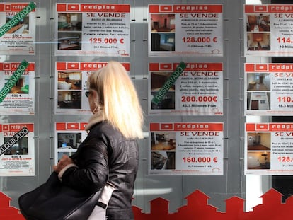 Carteles con pisos en venta en una oficina inmobiliaria en Madrid. 