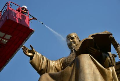 Un trabajador de Corea del Sur utiliza agua para lavar una estatua de bronce del Sejong, rey de Corea del siglo XV, en la plaza de Gwanghwamun, en Seúl.