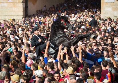 Un caballo se alza en la multitud durante la tradicional fiesta de San Juan en la localidad de Ciutadella, en la isla de Menorca.
