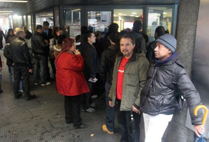 Varias personas hacen cola ante una oficina de empleo del Gobierno para inscribirse en el registro de ayudas sociales.
