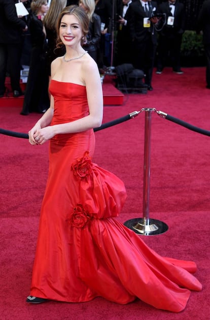 Anne Hathaway llega a la gala de los Oscar de 2011 con su primer modelo: un Valentino de cola rojo. Natalie Portman ganó la estatuilla a mejor actriz principal por 'El cisne negro'.