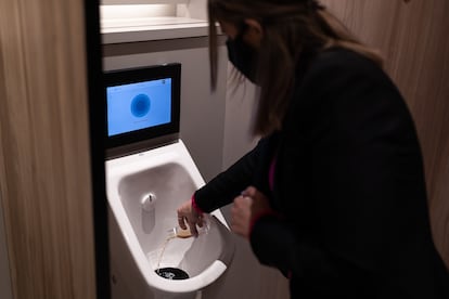 Una azafata realiza una prueba en el urinario inteligente de la Estación de Sants, en Barcelona.