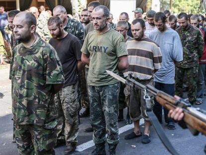 Pró-russos escoltam prisioneiros de guerra em Donetsk.