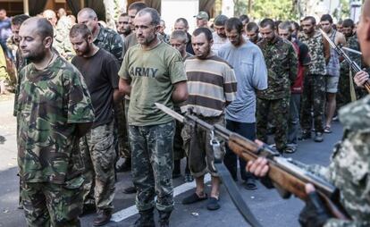 Pró-russos escoltam prisioneiros de guerra em Donetsk.