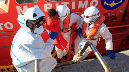 Los efectivos de rescate trasladan a un niño localizado en una patera.