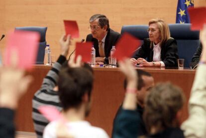 Varios estudiantes muestran tarjetas rojas a Rosa Díez, sentada junto al profesor  Rafael Calduch.