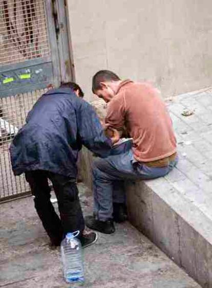 Unos jóvenes pinchándose en las inmediaciones de la narcosala del Raval, en la calle Arc del Teatre de Barcelona.