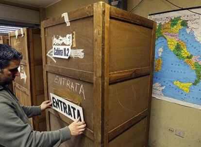 Un hombre coloca un cartel sobre una cabina en un colegio electoral de Roma, para las elecciones generales de hoy.