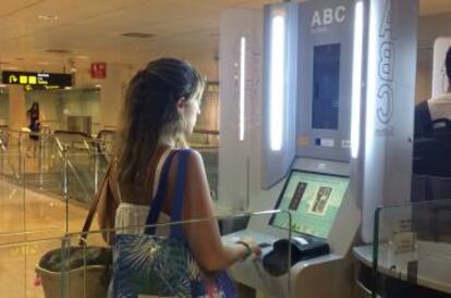 Una viajera usa una máquina automática de control de pasaporte.