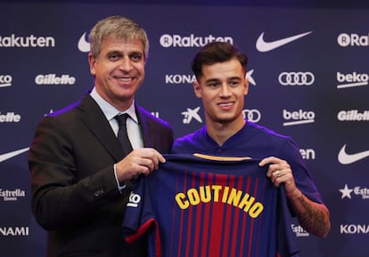 El nuevo fichaje del FC Barcelona Philippe Coutinho y Jordi Mestre posan con la camiseta del club durante la rueda de prensa.