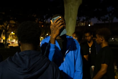 Un migrante intenta comunicarse con sus familiares desde el parque donde permanece toda la noche a la intemperie, el 7 de julio en Palma.