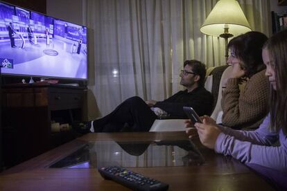 Una familia andaluza sigue un debate electoral por televisión.