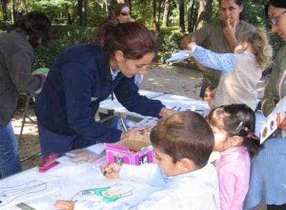 Varios niños dibujan en una actividad al aire libre en la Casa de Campo.